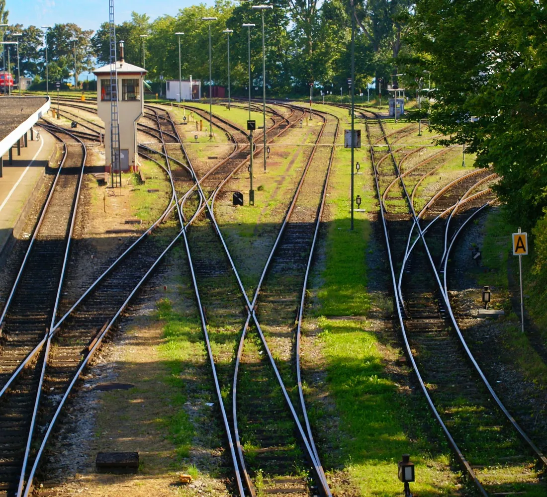 Raudteejaam pöörmete ja rööbastega päikesepaistel